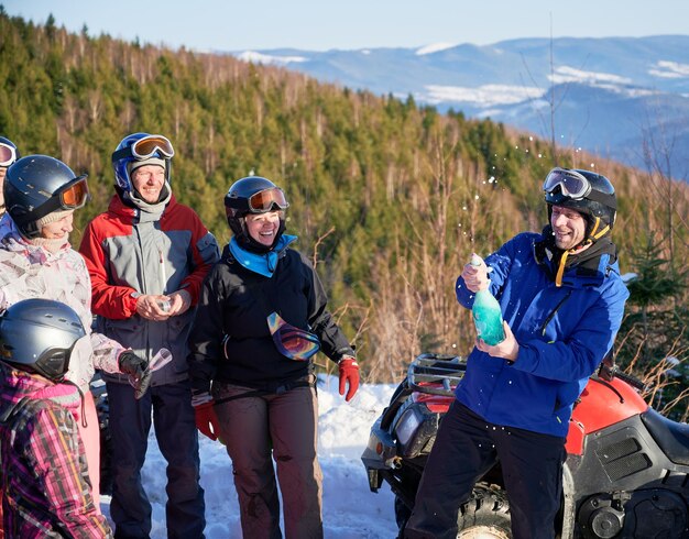 Voyageurs joyeux buvant du champagne dans les montagnes