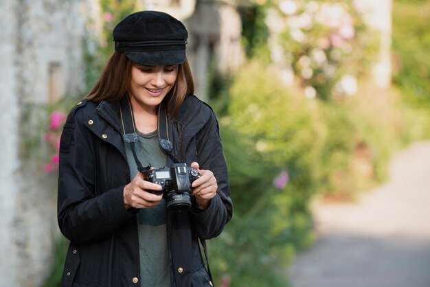 Voyageuse utilisant un appareil photo professionnel pour de nouveaux souvenirs