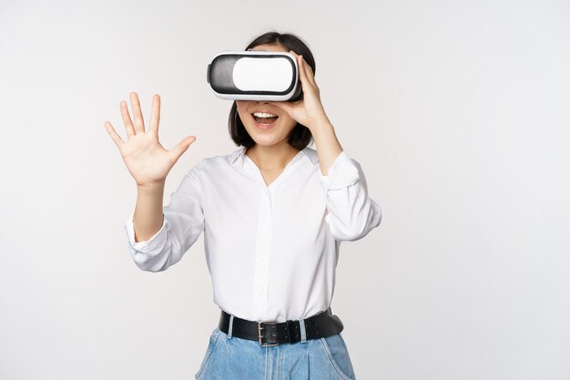 Vr chat fille asiatique disant bonjour dans des lunettes de réalité virtuelle souriant concept enthousiaste de communication et technologie future fond blanc