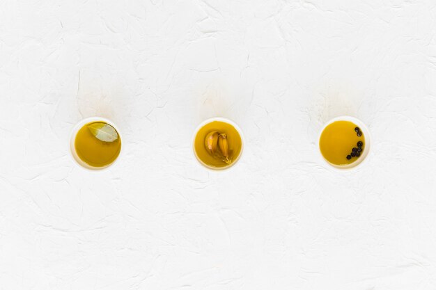 Vue aérienne de l&#39;ail vif, poivre noir et huile d&#39;olive sur fond blanc