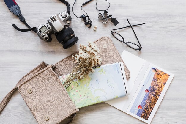 Vue aérienne de l&#39;appareil photo, sac à main et carte sur le bureau en bois