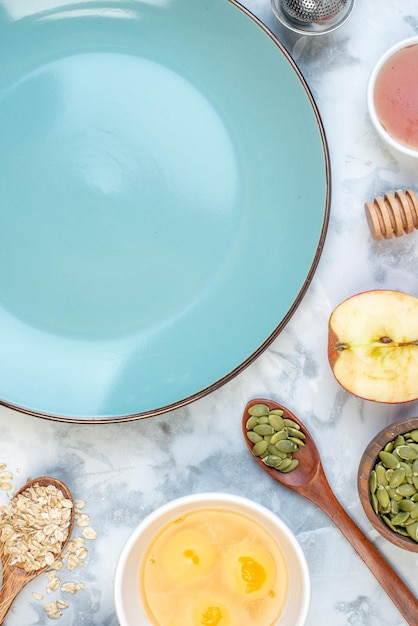 Vue aérienne d'une assiette vide bleue et d'ingrédients pour la nourriture saine sur une table de glace