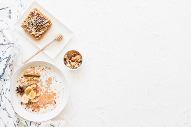 Vue aérienne de l&#39;avoine petit-déjeuner sain et des fruits secs sur fond blanc texturé