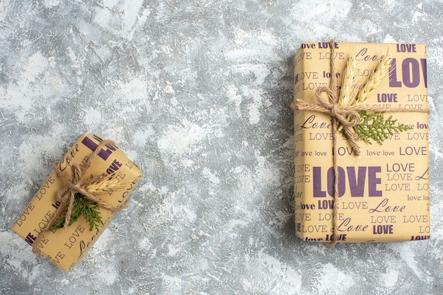 Vue aérienne de beaux cadeaux de Noël grands et petits emballés avec inscription d'amour sur la surface de la glace