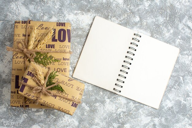 Vue aérienne de beaux cadeaux de Noël avec inscription d'amour sur un cahier ouvert sur une table de glace