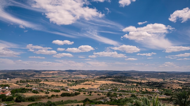Vue aérienne de champs verdoyants sous le soleil d'un beau matin de printemps. scène de la vallée andalouse avec de grandes étendues d'arbres. paysage rural de montagne de l'espagne. collines dans la communauté d'estrémadure