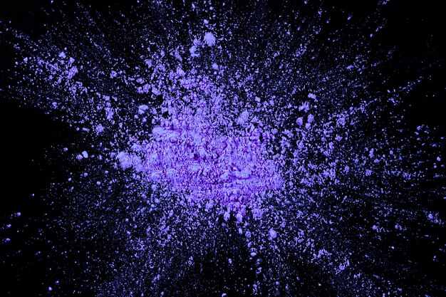 Vue aérienne de couleur violette explosant sur une surface sombre
