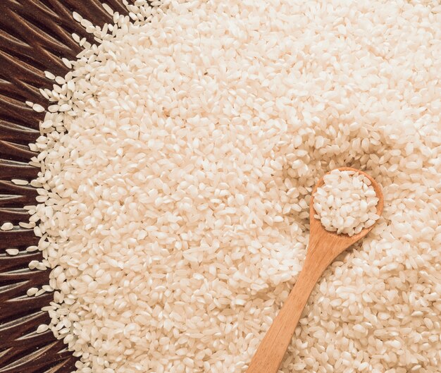 Vue aérienne d&#39;une cuillère de bois sur des grains de riz blancs