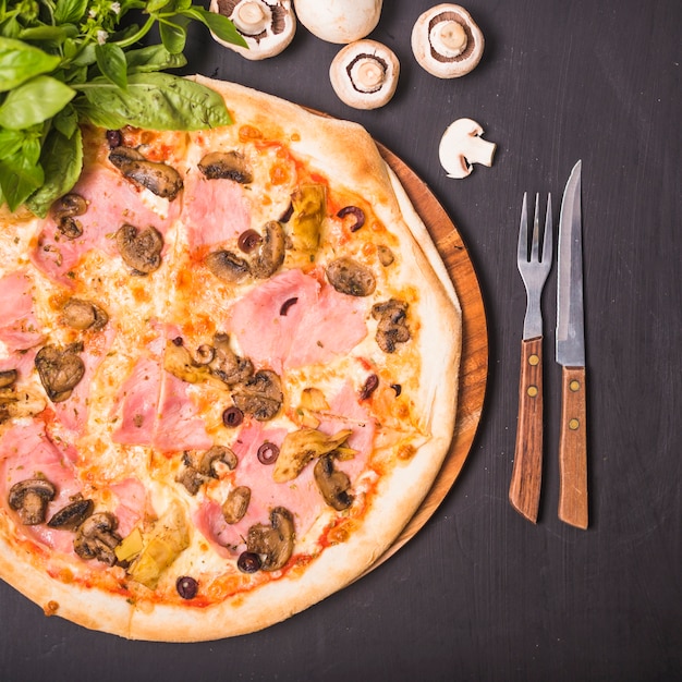 Une vue aérienne de délicieuses pizzas faites maison au basilic et aux champignons