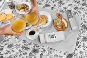 Photo gratuite une vue aérienne de deux personnes en train de griller des verres de jus de fruits au petit-déjeuner