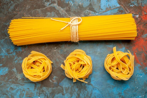 Vue aérienne de diverses pâtes italiennes pour la préparation du dîner sur fond bleu