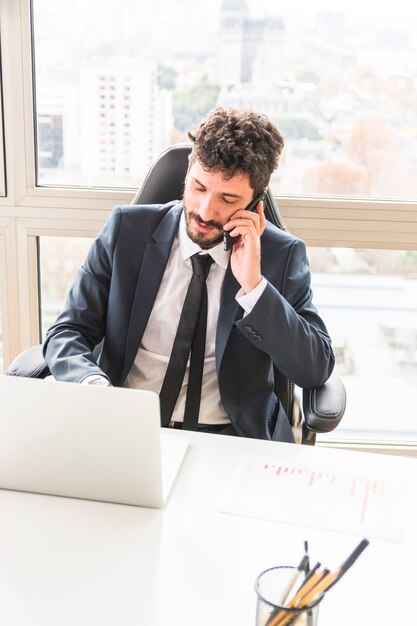 Une vue aérienne du jeune homme d&#39;affaires, parler au téléphone cellulaire au lieu de travail