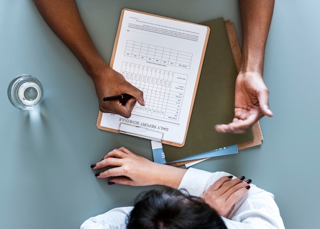 Photo gratuite vue aérienne du médecin rédigeant la liste de vérification du rapport quotidien du patient