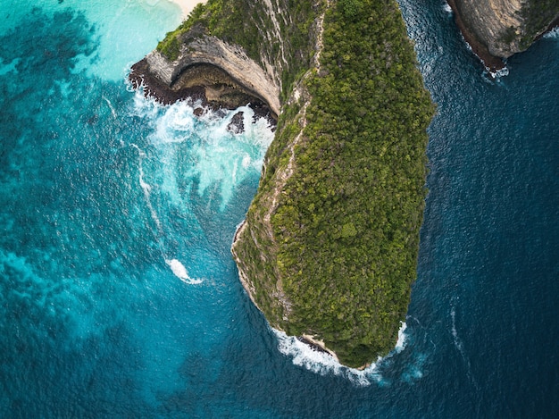 Vue aérienne des falaises couvertes de verdure entourées par la mer