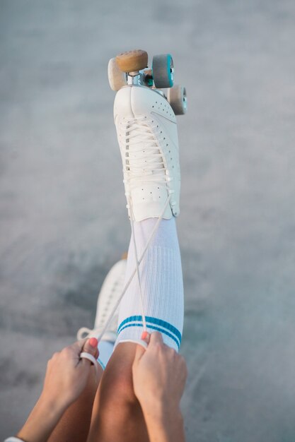 Une vue aérienne d&#39;une femme attachant la dentelle de patins à roulettes