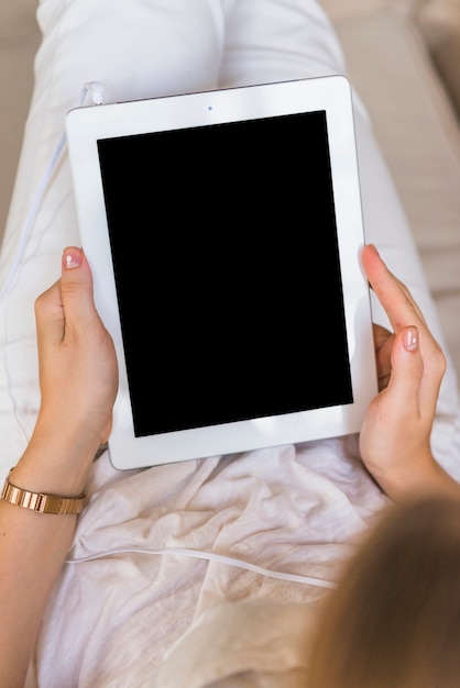 Vue aérienne de la femme tenant une tablette numérique avec écran blanc