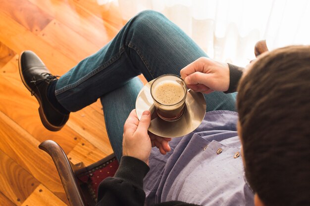 Vue aérienne, de, a, homme, s&#39;asseoir chaise, tenant tasse de café