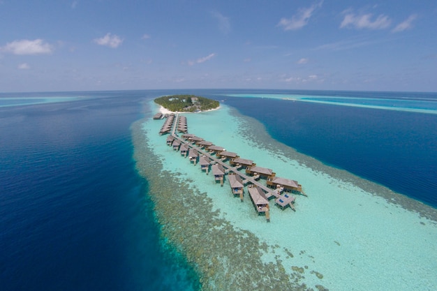 Vue aérienne d&#39;une île tropicale en eau turquoise. Villas luxueuses sur l&#39;eau sur les îles tropicales de Maldives pour les vacances, concept de fond de vacances - Traitement des couleurs haut de gamme.