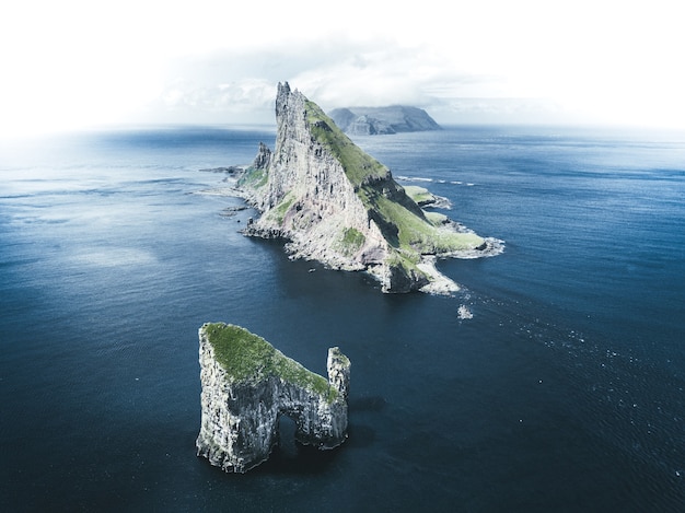 Photo gratuite vue aérienne d'îlots au milieu de la mer sous un ciel nuageux