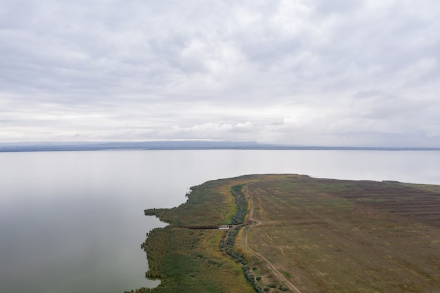 Vue aérienne à l'immense lac avec un sre vert et ciel en début de soirée