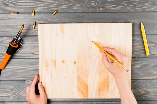 Vue aérienne de la main, dessin sur une planche de bois sur la table