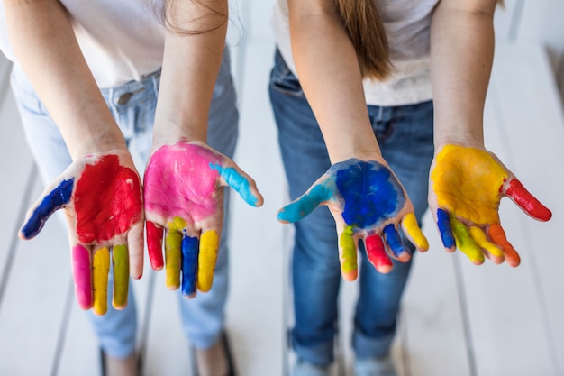 Une vue aérienne de la main de deux filles montrant leurs mains peintes