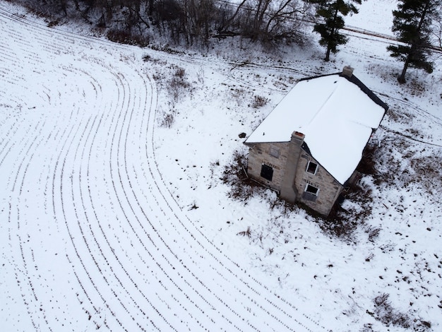 Vue aérienne d'une maison rurale avec des champs couverts de neige