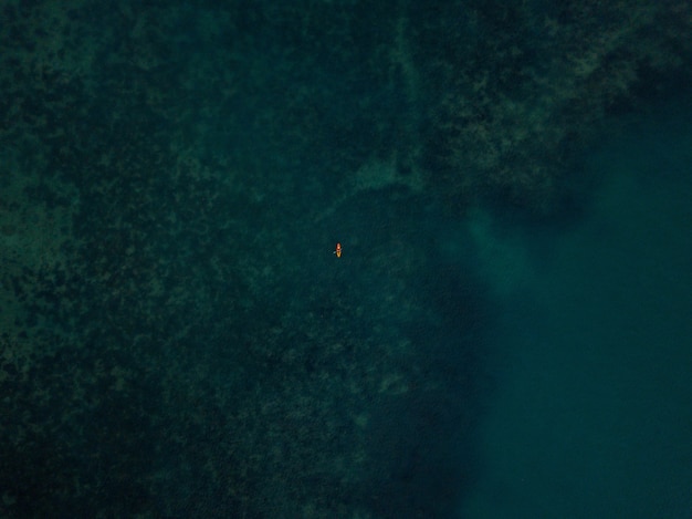 Vue aérienne de la mer avec un petit kayak visible au loin