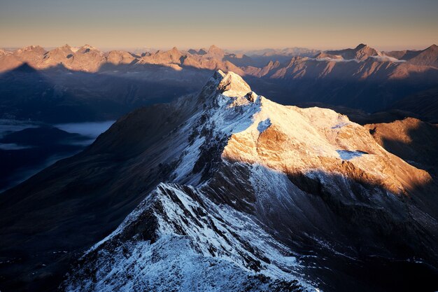 Vue aérienne de montagnes enneigées avec un ciel clair dans la journée