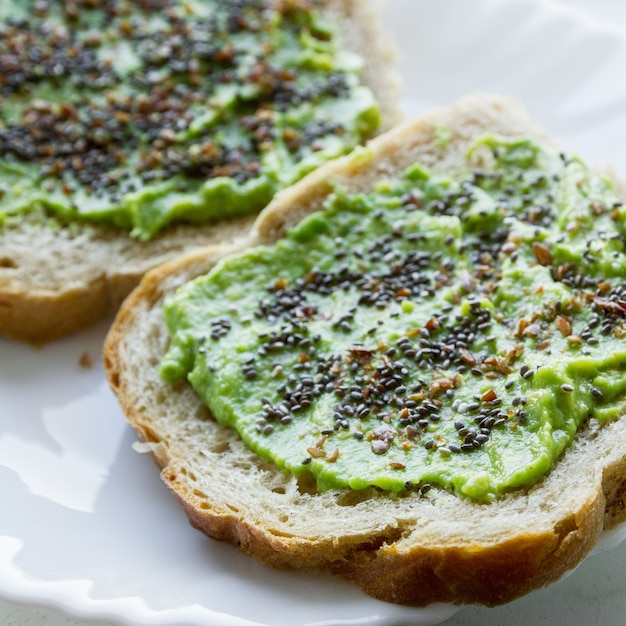 Photo gratuite vue aérienne d'un pain tartiné avec une crème d'avocat aux graines de chia