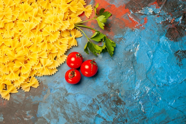 Vue aérienne de pâtes farfalle tomates vertes sur fond bleu