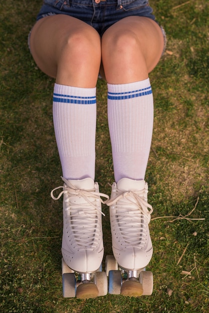 Photo gratuite vue aérienne d'une patineuse assise sur l'herbe verte