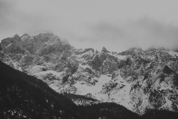 Vue aérienne d'un paysage montagneux recouvert de neige un jour brumeux