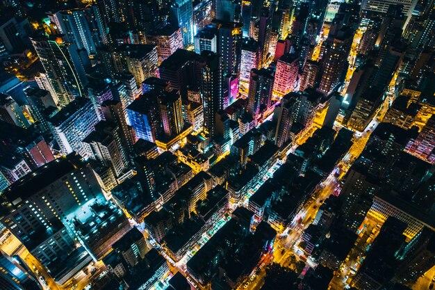 Vue aérienne d'un paysage urbain avec des immeubles de grande hauteur diffusant la lumière pendant la nuit