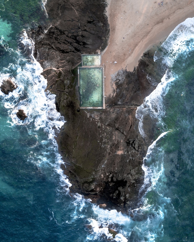 Photo gratuit vue aérienne de personnes nageant dans une grande piscine construite sur la côte rocheuse en thaïlande