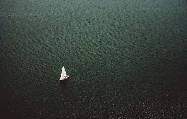 Vue aérienne d'un petit bateau naviguant dans le large et magnifique océan
