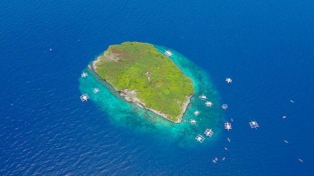 Vue aérienne de la plage de sable avec des touristes en train de nager dans une belle eau de mer claire de l&#39;île de Sumilon atterissant près d&#39;Oslob, Cebu, aux Philippines. - Accélérer le traitement des couleurs.