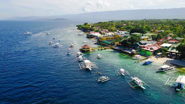 Vue aérienne de la plage de sable avec des touristes en train de nager dans une belle eau de mer claire de l&#39;île de Sumilon atterissant près d&#39;Oslob, Cebu, aux Philippines. - Accélérer le traitement des couleurs.