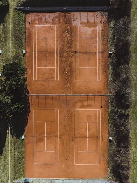 Vue aérienne de quatre terrains de sport reliés et entourés d'herbe verte