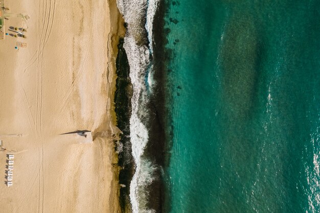 Vue aérienne de sable rencontrant l'eau de mer et les vagues