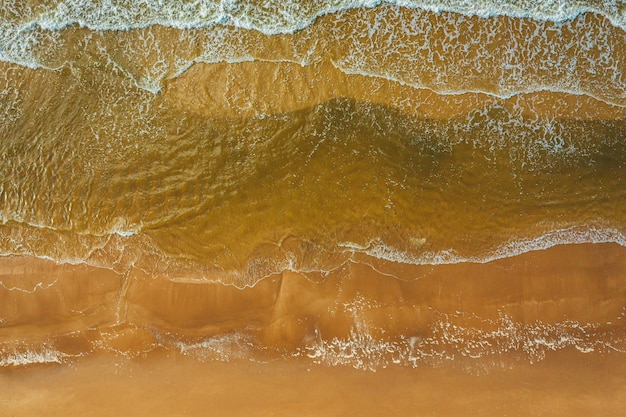 Vue aérienne de la vague de l'océan atteignant le littoral