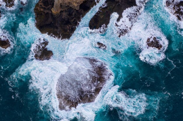 Vue aérienne des vagues se brisant sur les rochers