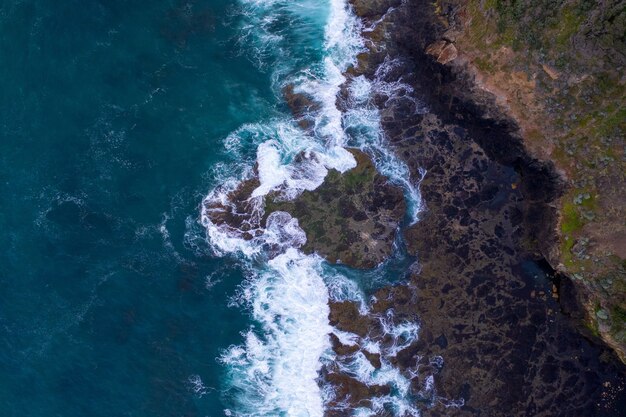 Vue aérienne des vagues se brisant sur les rochers