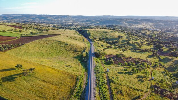 Vue aérienne de vastes terres agricoles avec une route de campagne au milieu