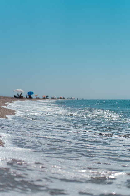 Vue aérienne verticale de la vague turquoise de l'océan atteignant le littoral