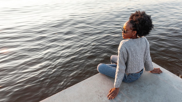 Vue africaine, femme assise, côté, eau