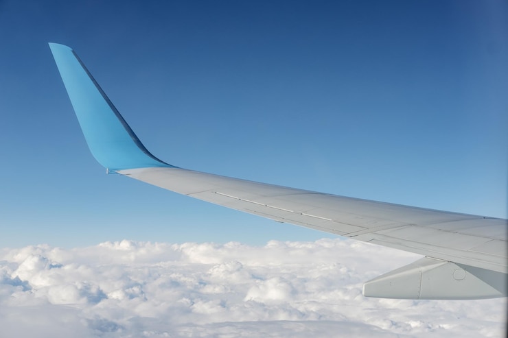 Photo gratuit vue de l'aile de l'avion depuis le siège de la fenêtre de l'avion ciel bleu et nuage