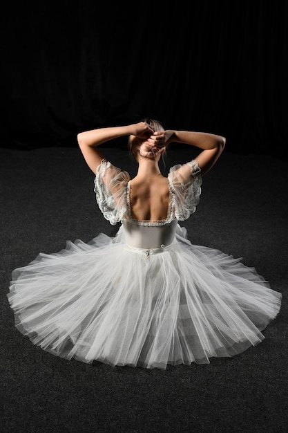 Vue arrière de la ballerine assise en robe tutu