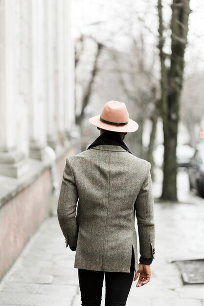 Vue arrière bel homme en veste grise marche