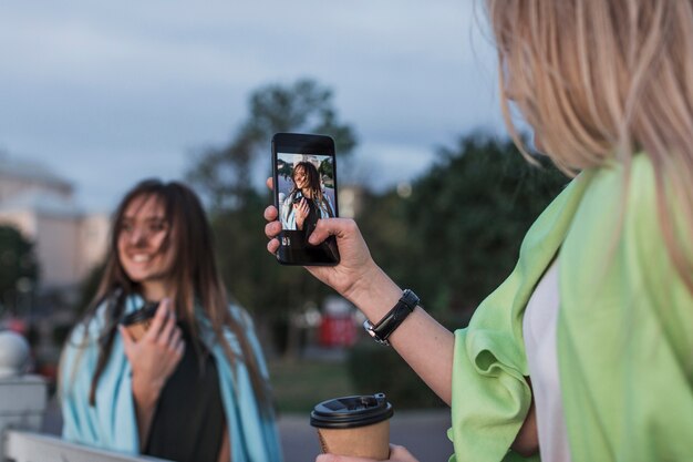 Vue arrière de la caméra photographiant une jeune femme